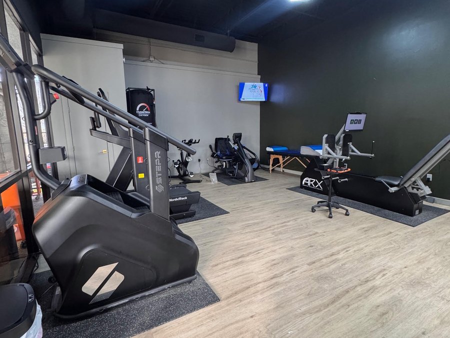 The training room at WLF Club, with the STEPR, the oxygen chamber, a bike, and the ARX leg press.