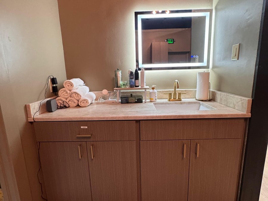 The spa vanity at WLF Club, with rolled towels, WLF lotion, and a backlit mirror.