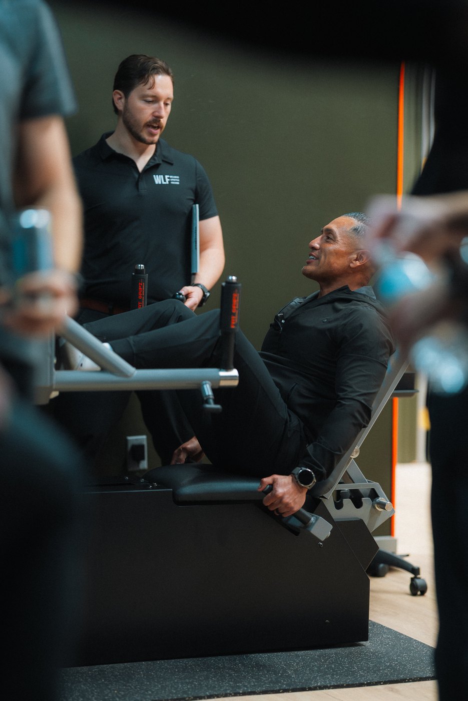 A WLF trainer working with a member on the ARX machine.