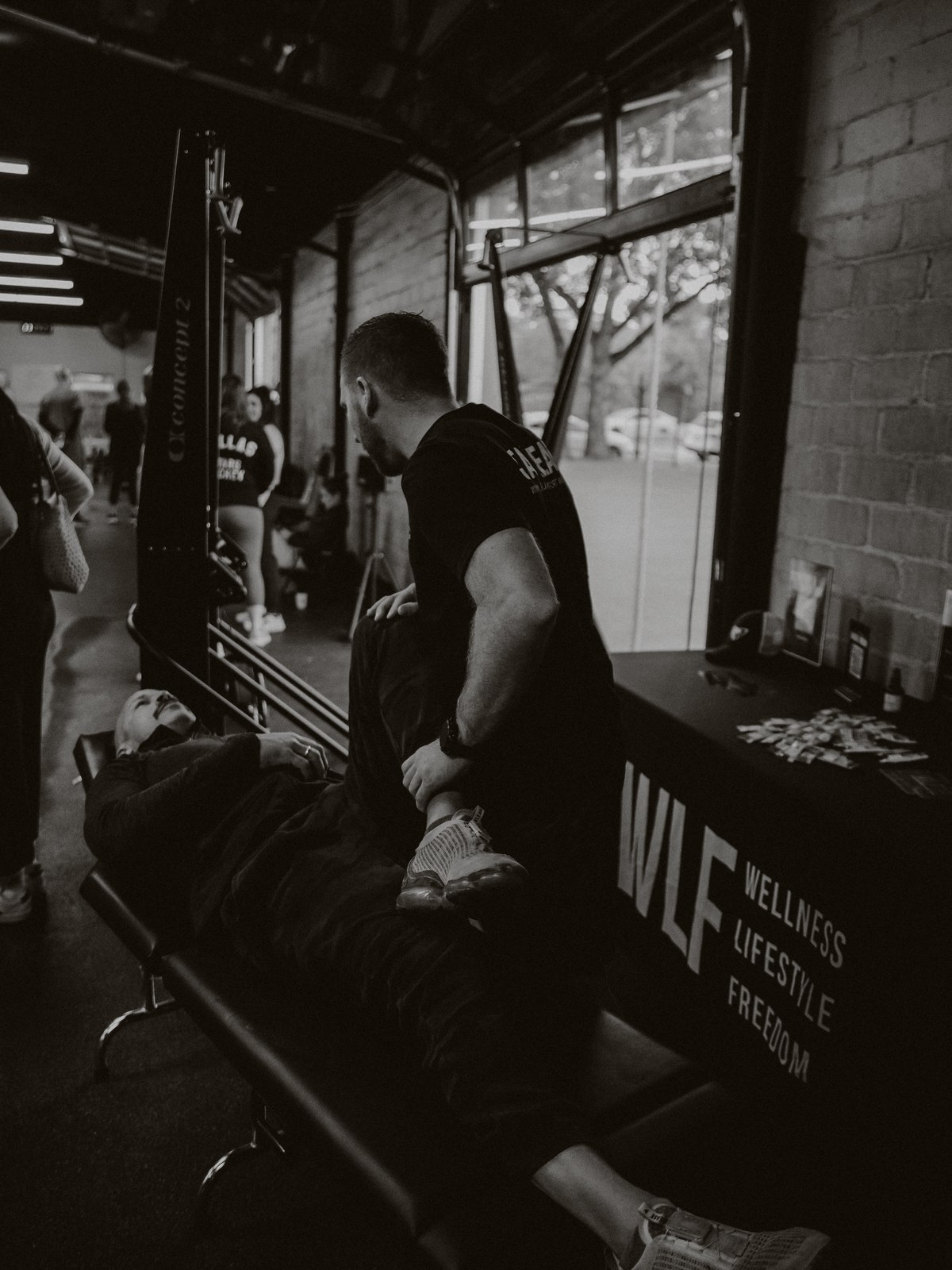 A WLF clinician working on a client's leg on the treatment table beside the WLF banner.