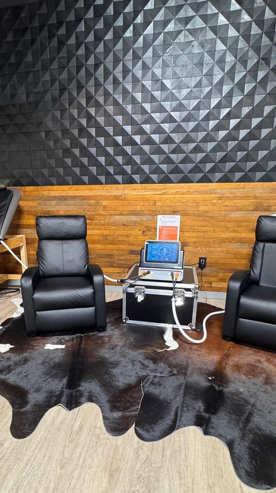 The PEMF unit at WLF Club, its touchscreen and coil applicators set up between the recovery recliners.